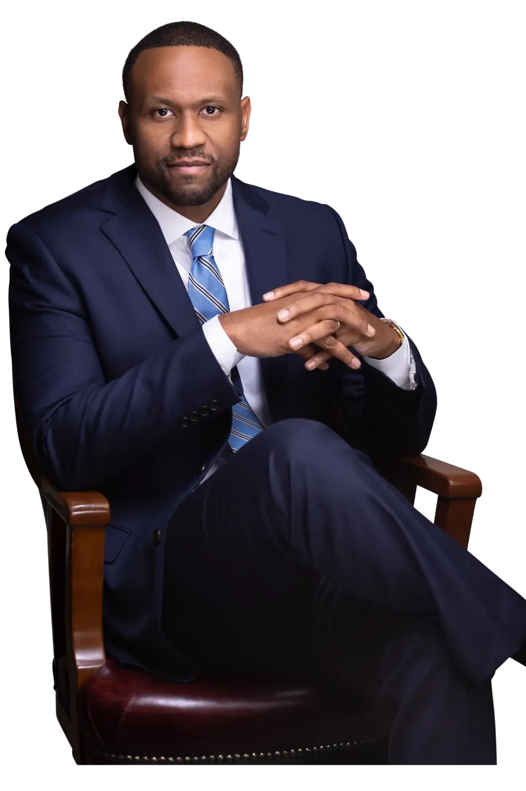 Attorney Stanley Thompson is seated in an armchair in a navy blue suit and tie